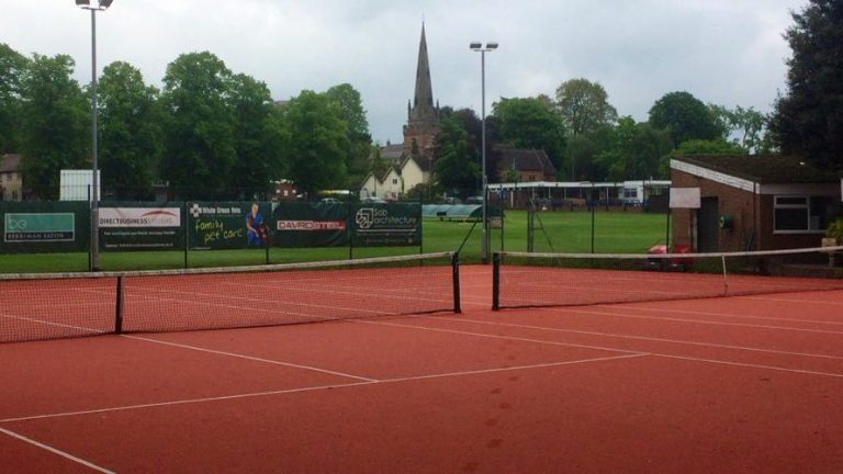 Clay tennis courts at Wombourne Tennis Club with the church spire behind