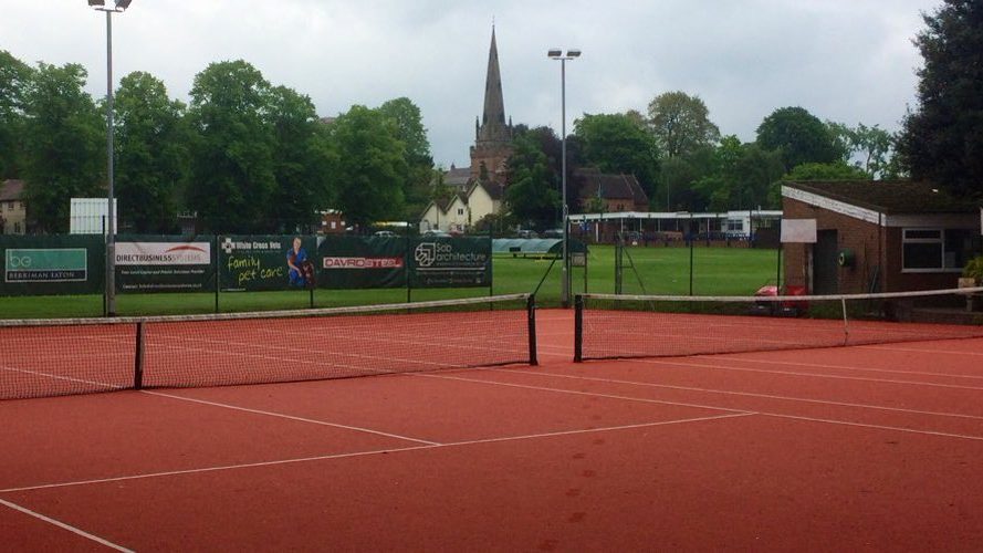 Clay tennis courts at Wombourne Tennis Club with the church spire behind